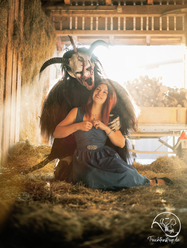 Schönes Mädchen im sexy Dirndl mit Krampus