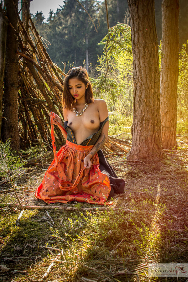 Schönes Mädchen zieht im Wald ihr sexy Dirndl Kleid aus