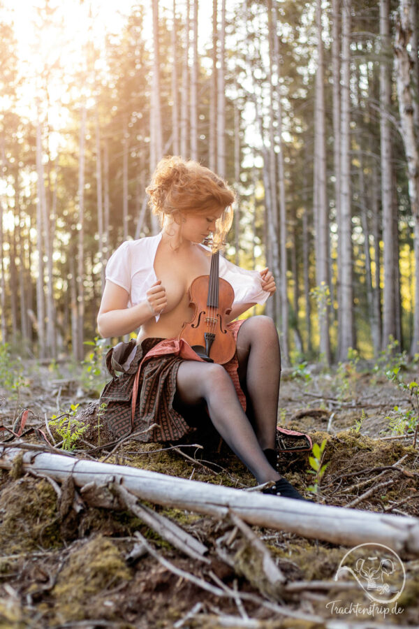 Beautiful girl with dirndl, suspenders and violin
