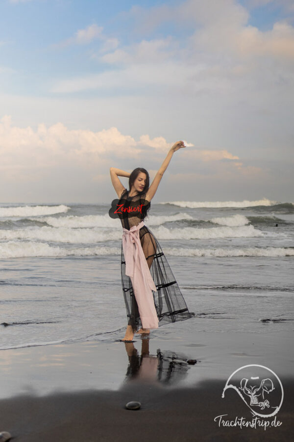 Kate in a transparent dirndl on the beach in Bali